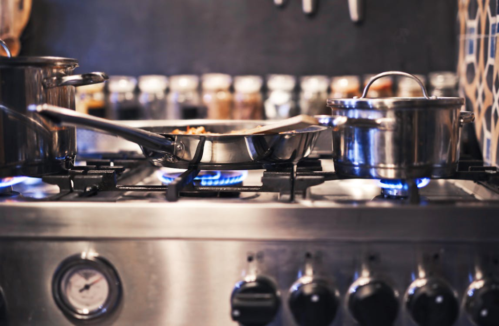 Three stainless steel cooking pots on a stove